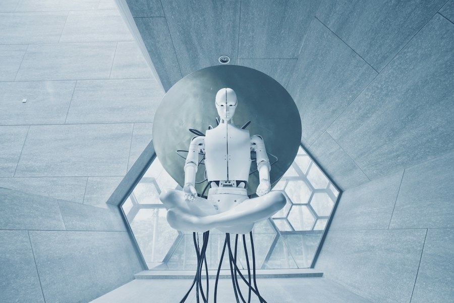 White humanoid robot seated in a lotus position inside a circular alcove