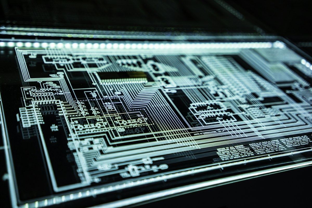 Transparent circuit board illuminated against a dark background