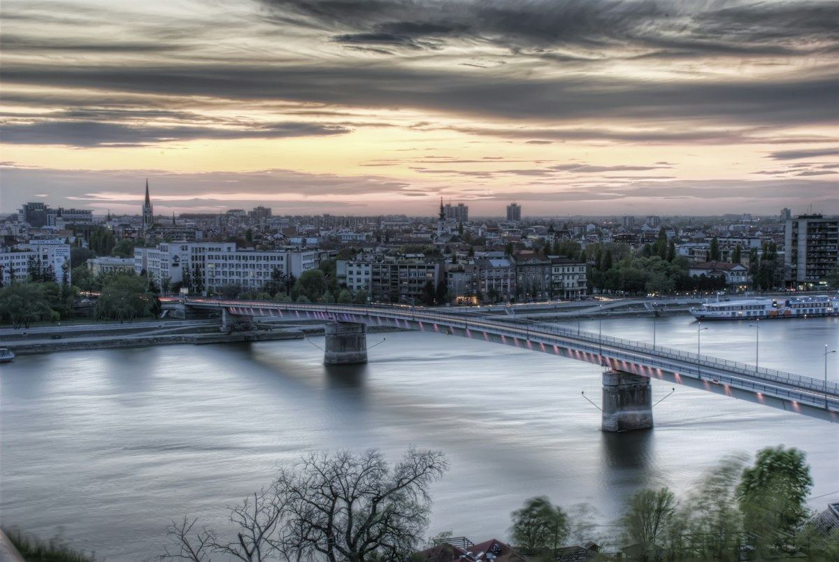 Novi Sad at dusk, with a bridge crossing the Danube toward the city skyline