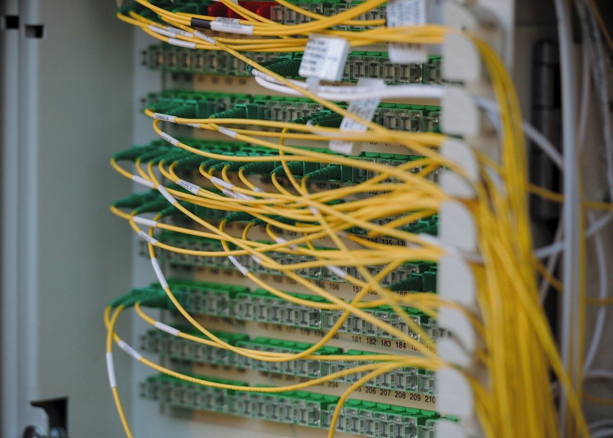 Fibre patch panel with yellow and green cables routed across network cards